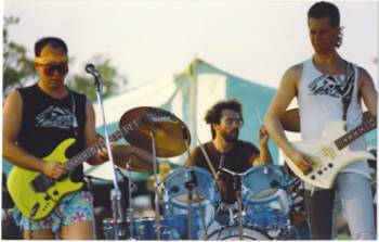 CERTAIN DEATH, 1987, at Chicago's annual "Peacefest", Montrose Harbor Park. (L to R) Danny Imig, guitar. Mike Imig, drums. Jeff Anderson, bass. Photo by Ron Zygmunt.